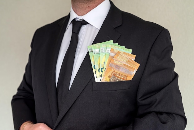 Business man wearing suit giving euro banknotes to subordinate office