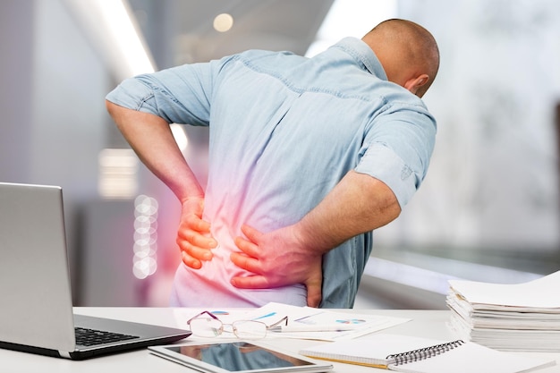 Business man with back pain an office . Pain relief concept