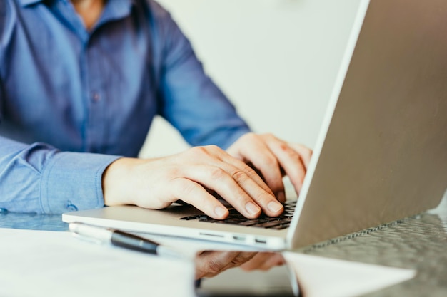 Business man with blue shirt sitting at his working place in office