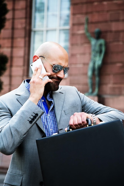 Business Man with Cellphone waiting and looking to his watch Photo