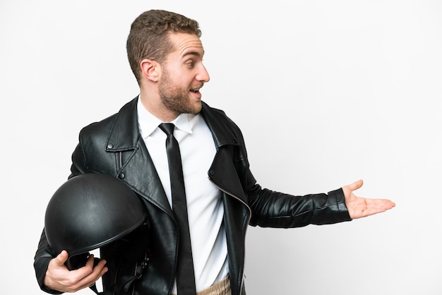 Business man with a motorcycle helmet over isolated white background with surprise expression while looking side