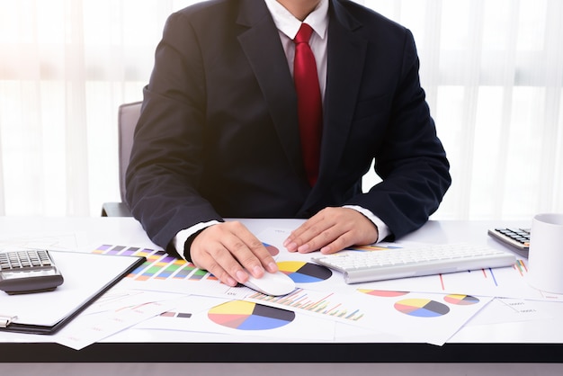 Business man working at office with desktop computer and documents on his desk