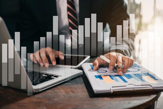 Business man working at office with laptop and tablet on documents on his desk, financial adviser analyzing data.