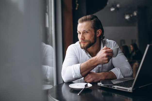 Business man working with laptop and drinking coffee in a cafe