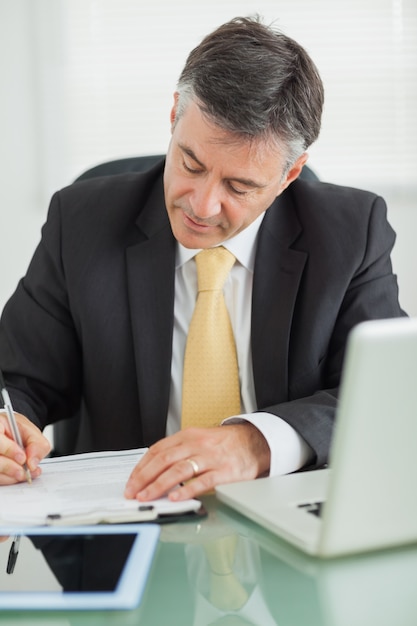 Business man writing on a notepad