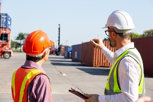 Business management discuss with foreman for communication before load container ship to customer.International cargo for distribution to warehouse.