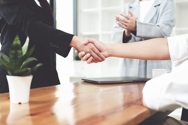 Business merger Asian businessman shake hands at the conference room with showcase their collaboration to strengthen their marketing efforts