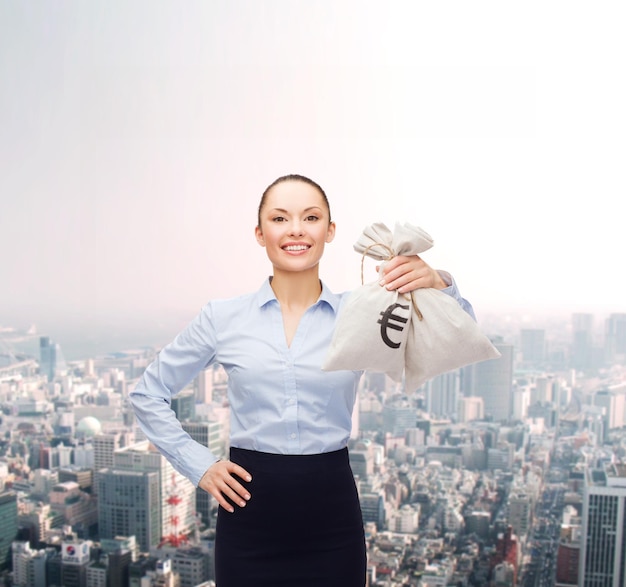 business and money concept - young businesswoman holding money bags with euro