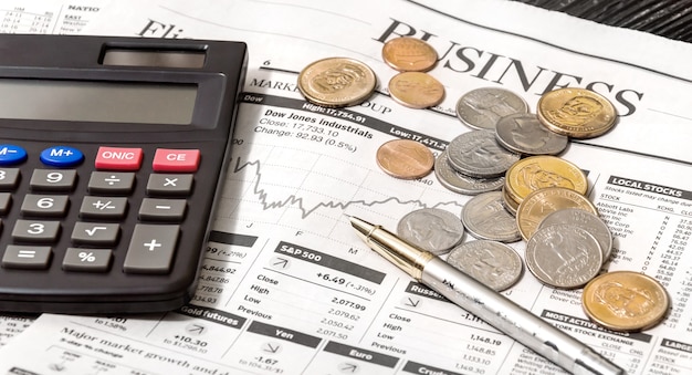 Business newspaper with calculator and coins