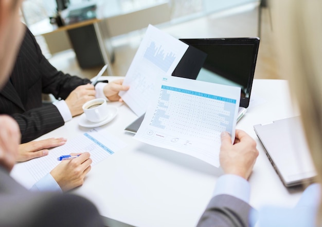 business and office concept - close up of business team with files and laptop computer in office