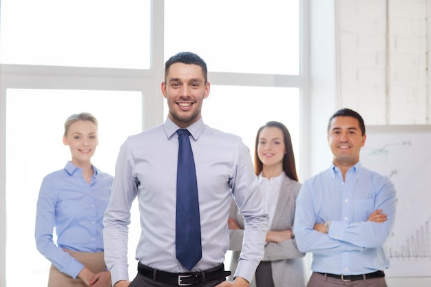 business and office concept - smiling handsome businessman with team in office