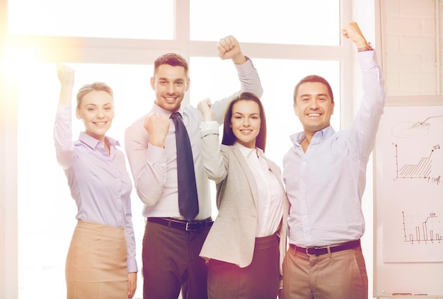 business, office, success and victory concept - happy business team celebrating victory in office