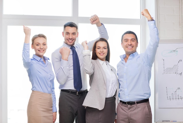 business, office, success and victory concept - happy business team celebrating victory in office