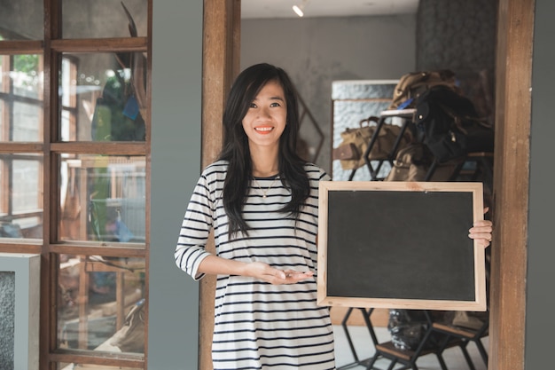 Business owner holding a blackboard