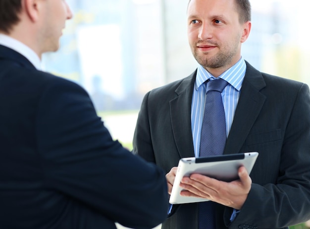 Business partners working in hallway with electronic tablet