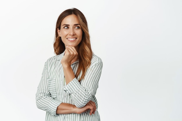 Business people. Ambitious and confident businesswoman, smiling pleased, looking aside thoughtful and pleased