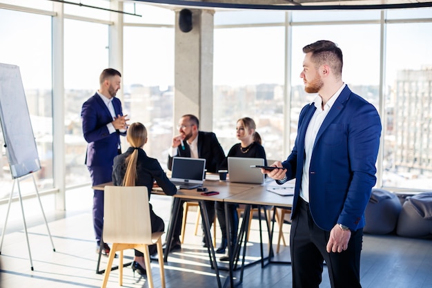 Business people, businessmen are working together in a modern office in a multi-storey skyscraper. The director is on the phone. Office work concept. Selective focus