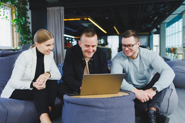 Business people colleagues discuss business looking at laptop modern workspace Colleagues work together in the office