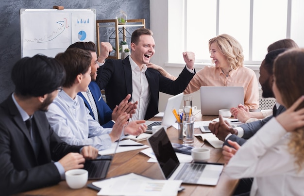 Business people congratulate colleague with his success during business meeting