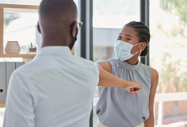 Business people covid and elbow greeting for social distance or health and safety during pandemic at the office Man and woman employee elbow bump with face masks for workplace rules and regulations