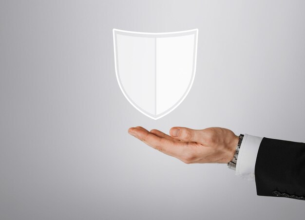 Photo business, people and cyber protection concept - close up of male hand with virtual antivirus program shield icon over gray background