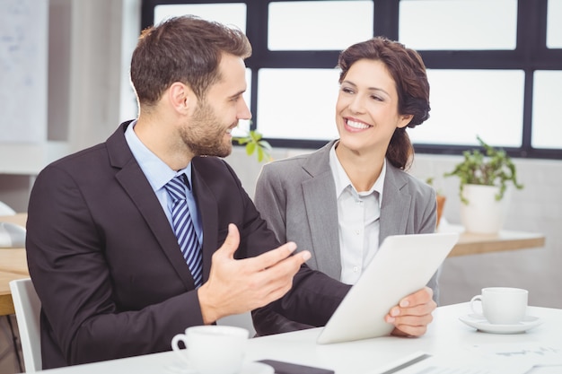 Business people discussing over digital tablet