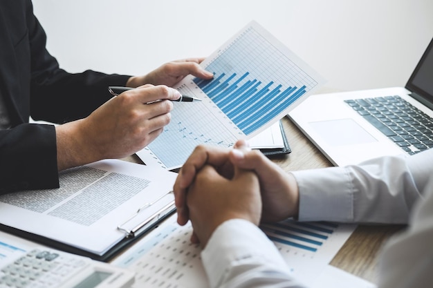 Business people discussing graphs on desk