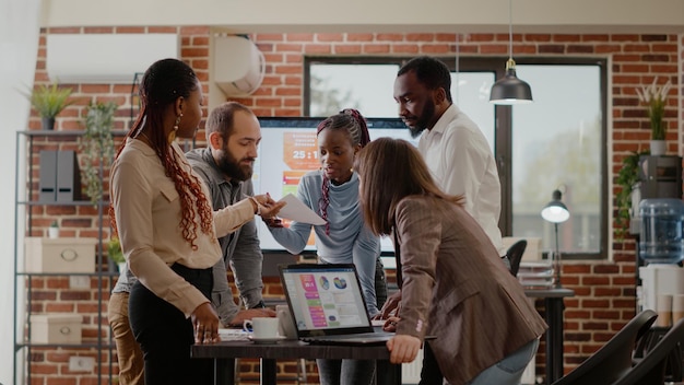 Business people doing teamwork for project planning in office, using files with statistics and laptop to design financial presentation. Colleagues working with data analysis for strategy.