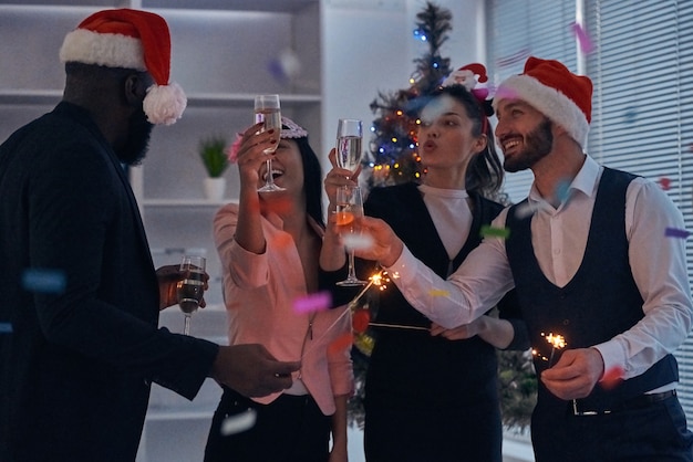 The business people drinking champagne on the christmas tree background