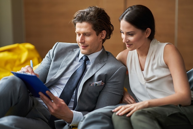 Business people Having Meeting On Poufs In Modern Office