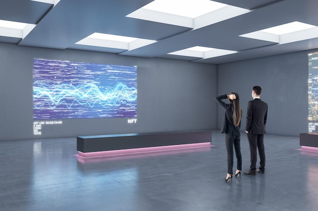 Business people looking at modern digital picture on grey wall in stylish loft interior design exhibition gallery art investing and NFT concept