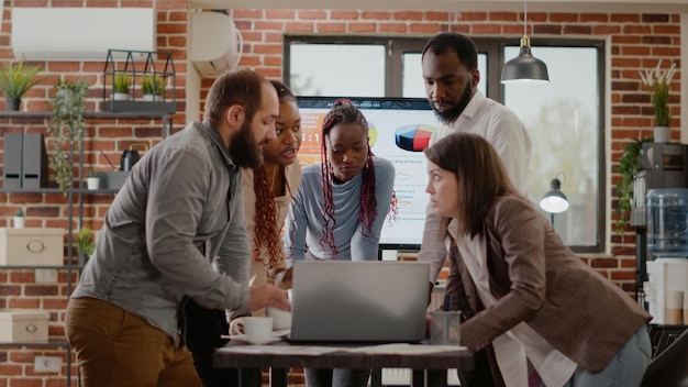 Business people meeting to discuss project planning and strategy for company development. Coworkers talking about marketing and management, using laptop and documents on office desk.