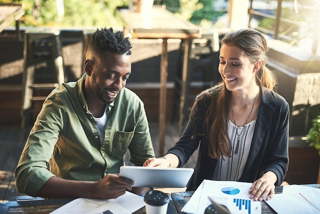 Business people meeting and discussion with tablet for finance budget or company results on revenue at cafe Businessman and woman discussing financial growth on technology for profit or investment