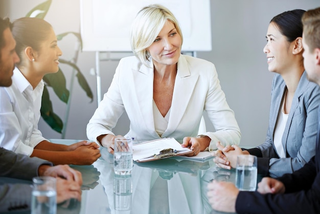 Business people in a meeting woman executive and discussion in conference room with diversity in corporate group Men women and female leadership with paperwork team leader and collaboration