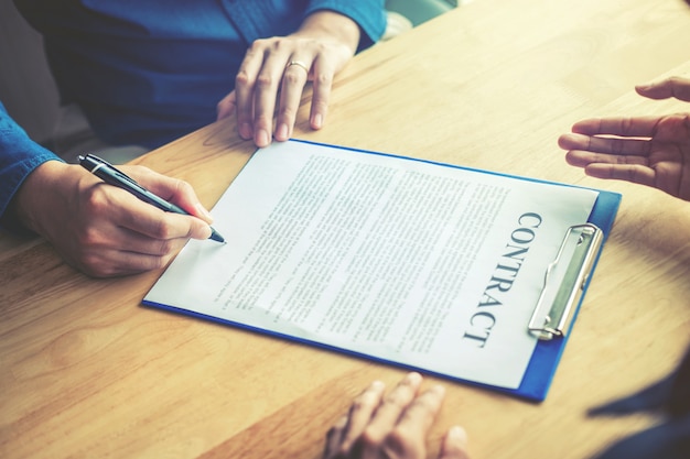 Business people negotiating a contract between two colleagues