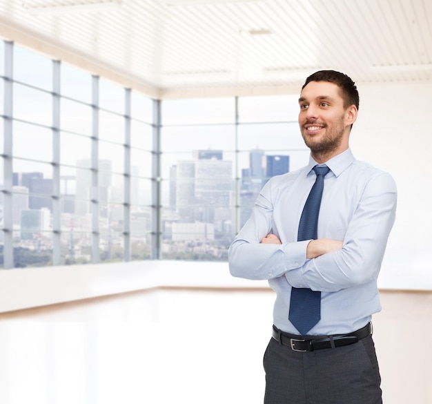 business, people and office concept - happy young buisnessman over office room or new apartment background