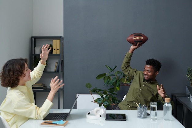 Business people playing rugby in office