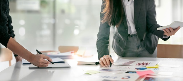 Business people pointing graphs and charts to analyze market data balance sheet account net profit to plan new sales strategies at office