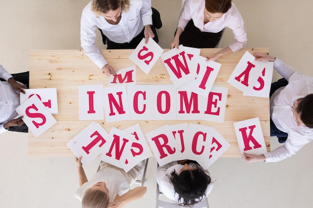 Business people putting letters INCOME