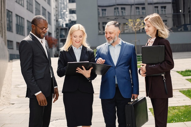 Business people standing and talk to each other in front of modern office