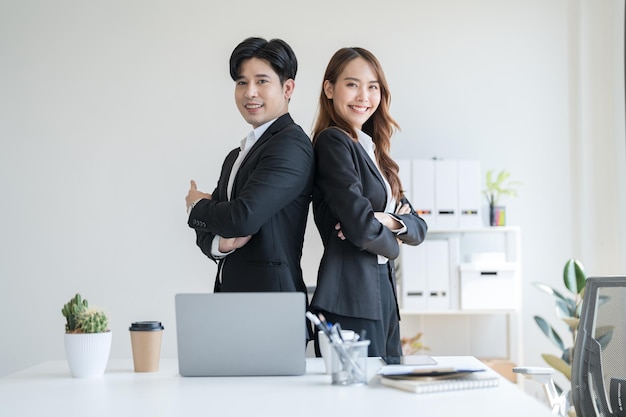 Business people standing with their backs to each other in the office