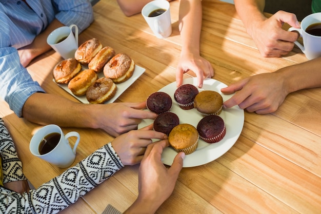 Business people taking cakes on table