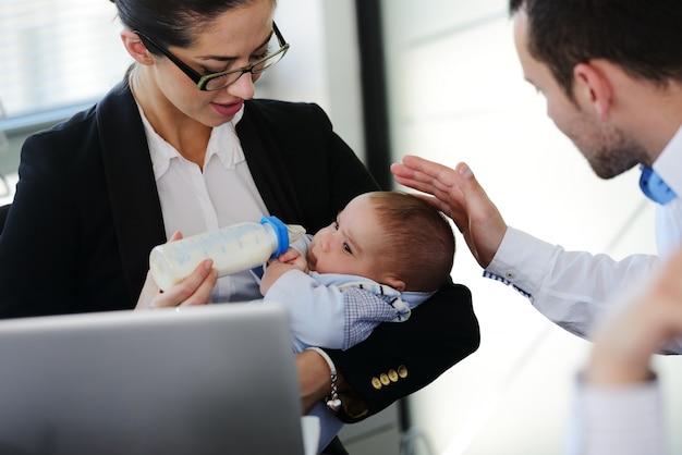 Business people taking care of baby in office