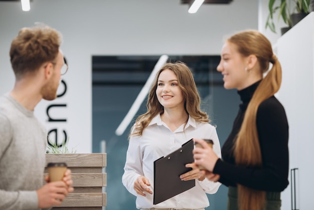 Business people talking while holding coffee cups at office cafeteria