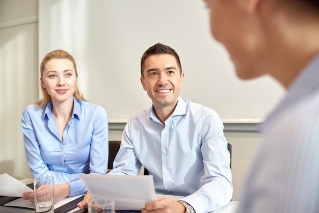 business, people and teamwork concept - group of smiling businesspeople meeting in office