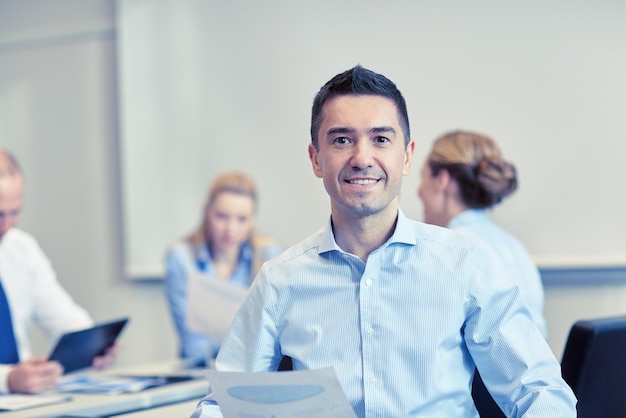 business, people and teamwork concept - smiling businessman with group of businesspeople meeting in office