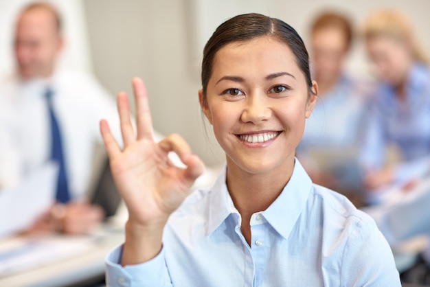 business, people and teamwork concept - smiling businesswoman with group of businesspeople meeting in office