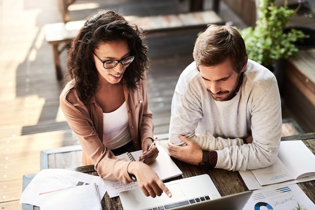 Business people teamwork and discussion with laptop at cafe with meeting paperwork or remote work Partnership data analysis or top view for brainstorming ideas with strategy planning or solution