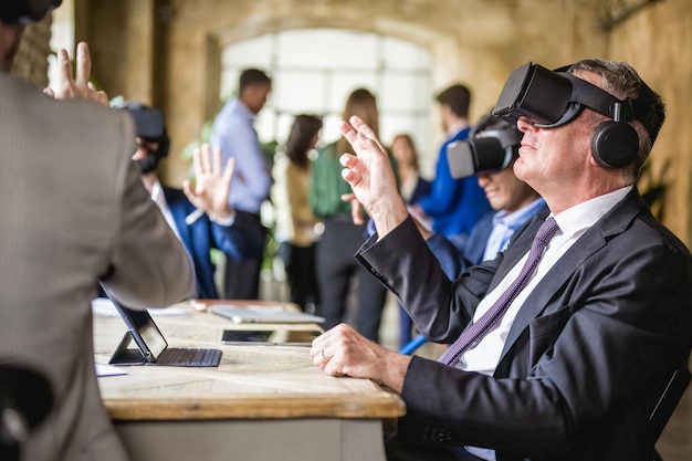 Business people using augmented reality headset for a virtual meeting senior businessman scrolling documents in virtual space and searching information reports futuristic business workplace