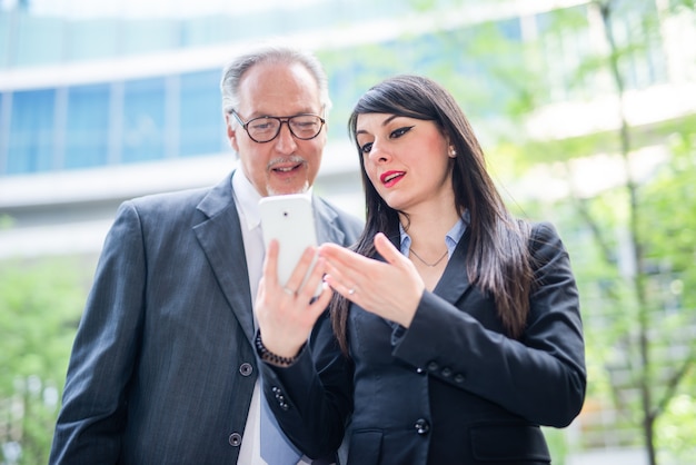 Business people using a tablet, outdoor office work concept